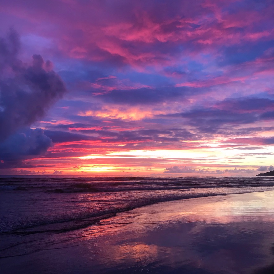 Dramatic purple and pink sunset over ocean beach