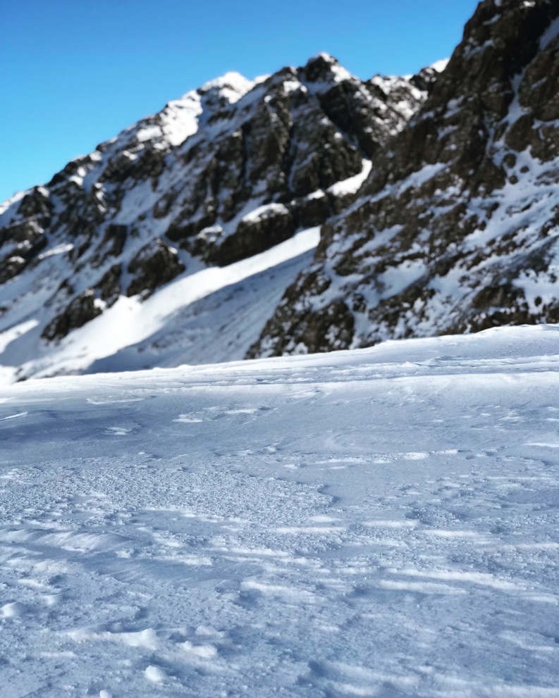 Snow-covered mountain peak with exposed rocky cliffs